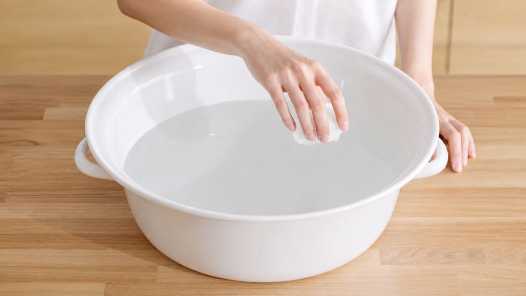 Hòa tan nước giặt vào chậu nước ấm